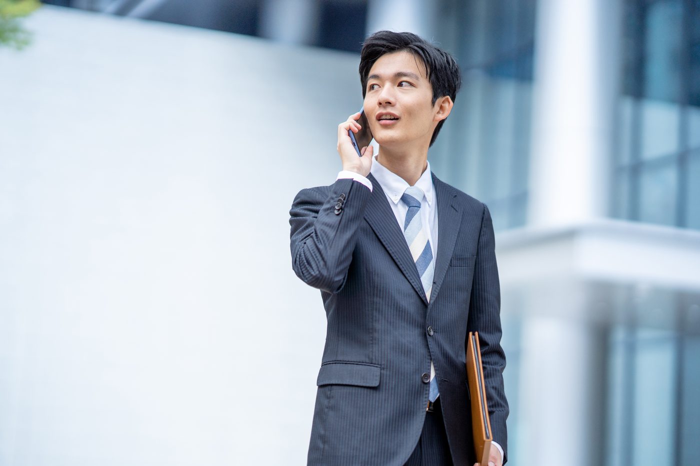 オフィス街で電話をする若手ビジネスマン